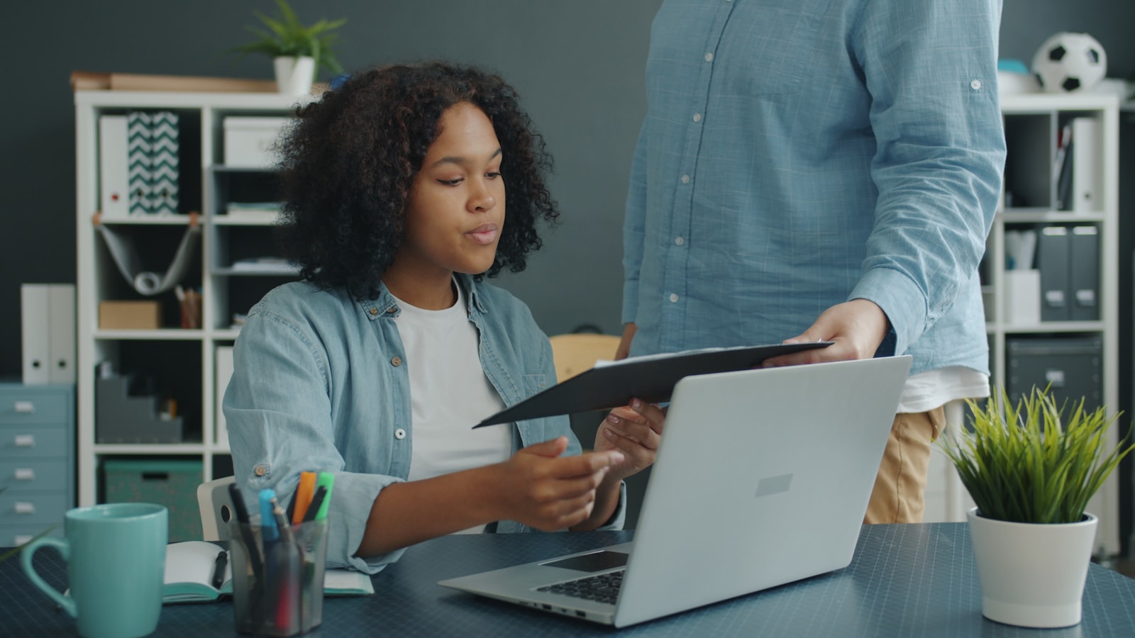 Two support coordinators reviewing a participant's compliance records together